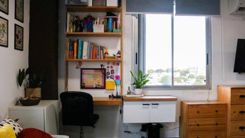 un bureau dans une pièce avec une fenêtre et un ordinateur dans l'établissement The Alexa tiny apartment city view for 3 guests, à San Juan