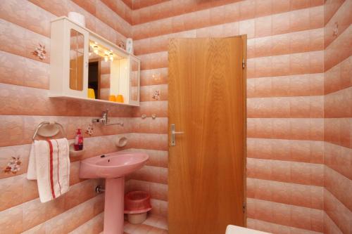 a bathroom with a pink sink and a mirror at Apartment Opric 7695a in Opric