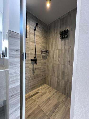 ein Badezimmer mit Dusche und Holzwand in der Unterkunft BoxPoint MotoResort in Cordoba