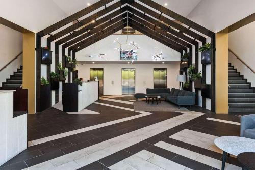 a lobby with stairs and couches in a building at VAQUAY Belladonna In Abbotsford in Melbourne