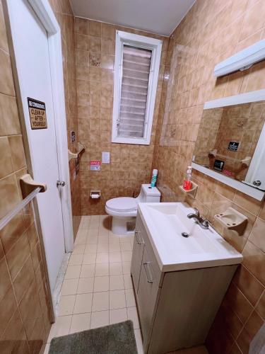a bathroom with a sink and a toilet and a window at Amazing private Room in Glendale