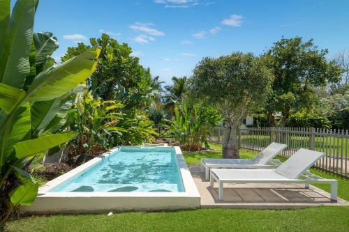 a swimming pool with two chairs and a table at Adora Villa in Ewingsdale