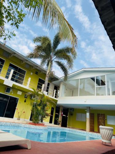 a house with a swimming pool and a palm tree at Hotel Pousada Aquarius SOB NOVA DIREÇÃO in Aruanã
