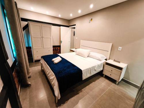 a bedroom with a large bed with a blue blanket at Refúgio cercado pela natureza em Pomerode in Pomerode