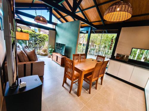 a dining room with a wooden table and chairs at Refúgio cercado pela natureza em Pomerode in Pomerode