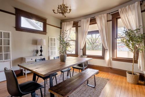 une salle à manger avec une table et des chaises en bois et des fenêtres dans l'établissement Stay Portland - 4BR Historic Soul District Remodel w Detached Unit, à Piedmont