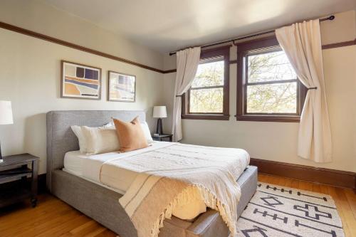 une chambre avec un grand lit et deux fenêtres dans l'établissement Stay Portland - 4BR Historic Soul District Remodel w Detached Unit, à Piedmont