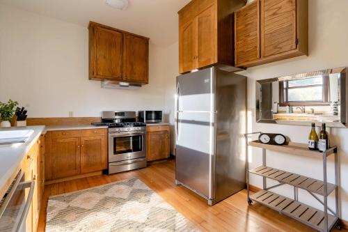 a kitchen with a stainless steel refrigerator and wooden cabinets at 2BR Historic Soul District Remodel in Portland