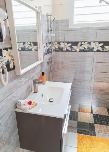 a bathroom with a sink and a shower at T3 Serenity aux couleurs du soleil à Ducos in Ducos