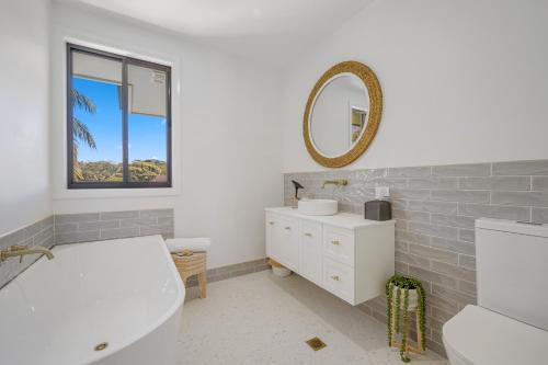 Un baño con bañera, lavabo y espejo. en 13 Jordan, en Bonny Hills