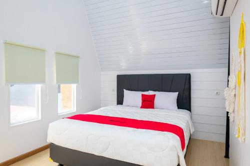 Schlafzimmer mit einem großen Bett und einem roten Kissen in der Unterkunft RedDoorz @ myRoom UMY in Yogyakarta