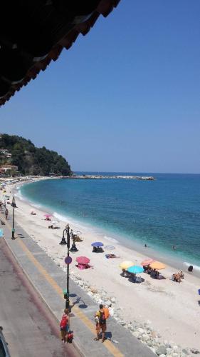 a beach with people and umbrellas and the ocean at MARIA Studios & Apartments in Agios Ioannis Pelio