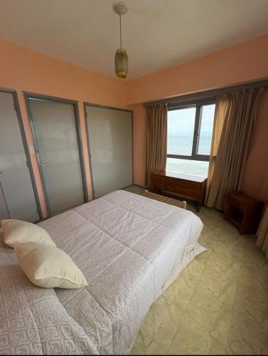 een slaapkamer met een groot bed met een groot raam bij Miramar Vista al Mar in Miramar