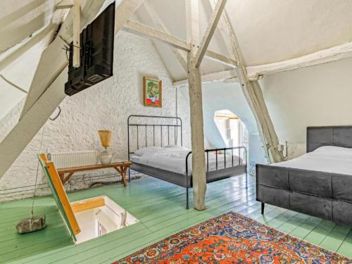 a bedroom with two beds and a tv on the wall at Spacious chateau with garden in the Loire Valley in Palluau-sur-Indre