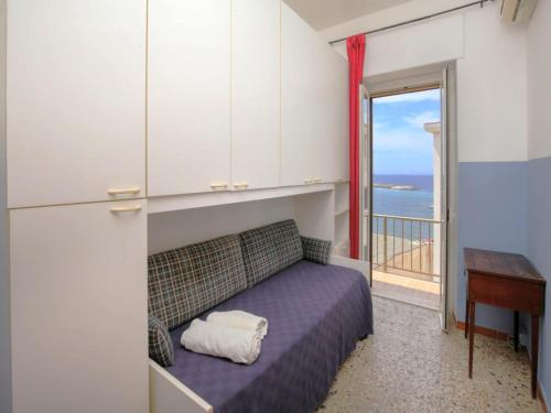 a bedroom with a bed and a desk and a window at Holiday home with sea view and large terrace in Castelsardo