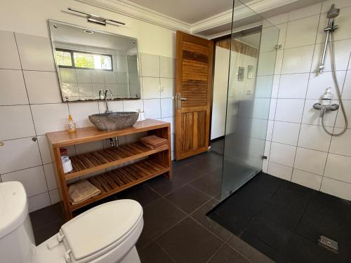 a bathroom with a toilet and a sink and a shower at Anggrek Putih Cooking Class & Guest House in Senggigi 