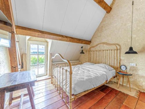 a bedroom with a bed and a table and a window at Gites for 2 people at a chateau with a garden in Palluau-sur-Indre