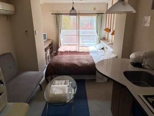 a small room with a bed and a window at フューデイズコンドミニアム定山渓106号室 in Jozankei