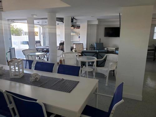 a dining room with a table and blue chairs at Oceanside Single Family Brant Beach Beach Badges Rooftop Deck Wifi Private Yard Washer & Dryer in Beach Haven Crest