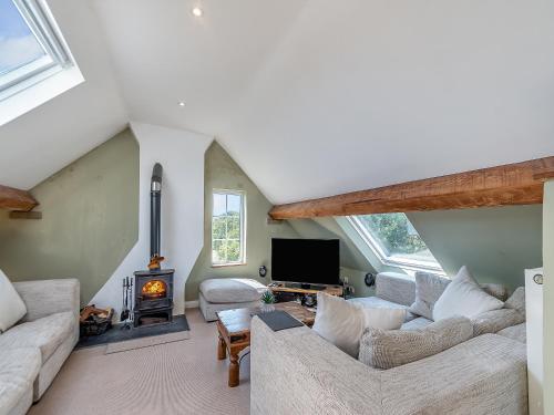 ein Wohnzimmer mit zwei Sofas und einem Kamin in der Unterkunft Chapel Bay Cottage in Angle