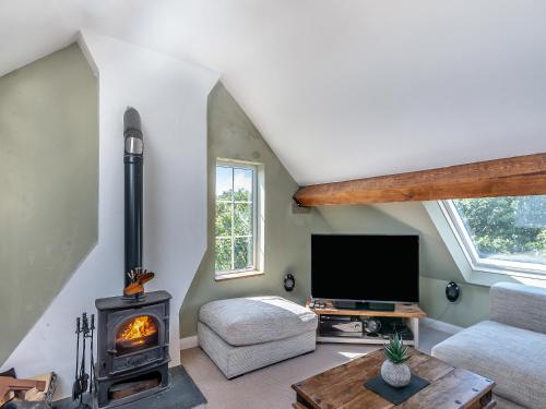 ein Wohnzimmer mit Kamin und Fernseher in der Unterkunft Chapel Bay Cottage in Angle