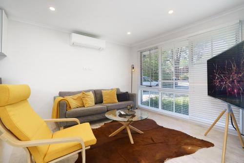 a living room with a couch and a tv at Stylish 3Bedroom Escape in South Canberra - Hosted by Canstay in Kambah