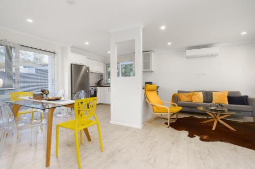 a kitchen and living room with a table and yellow chairs at Stylish 3Bedroom Escape in South Canberra - Hosted by Canstay in Kambah
