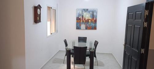 a dining room with a glass table and black chairs at Le Nid d'azrou in Azrou