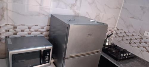 a small kitchen with a stainless steel refrigerator at Le Nid d'azrou in Azrou