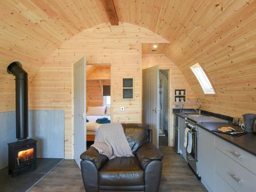 a kitchen with a leather chair and a stove at Creyr Glas Pod -Uk41796 in Hirnant