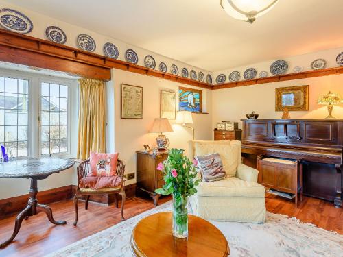a living room with a table and a piano at Brandon in Sutton on Sea