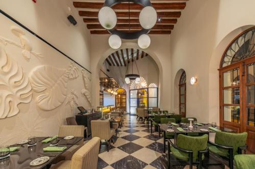 a restaurant with tables and chairs and a chandelier at Pueblo Bonito Vantage Centro Histórico Mazatlán in Mazatlán