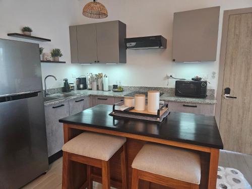 una cocina con una isla con 2 taburetes en Mireyas Sweet Escape with private Jacuzzi, en Las Terrenas