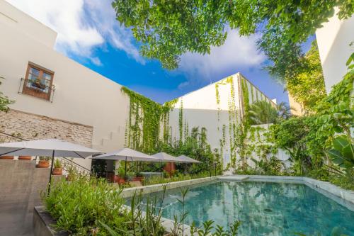 a swimming pool in the courtyard of a building with umbrellas at Pueblo Bonito Vantage Centro Histórico Mazatlán in Mazatlán