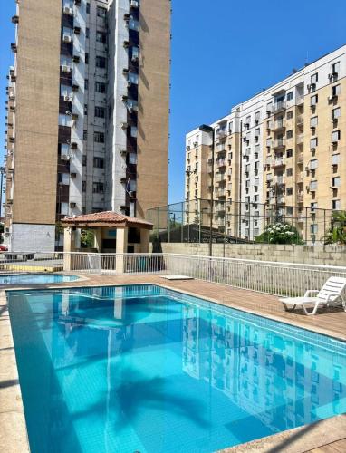 a swimming pool with two tall buildings in the background at Apartamento 2 quartos para a cop 30 in Ananindeua