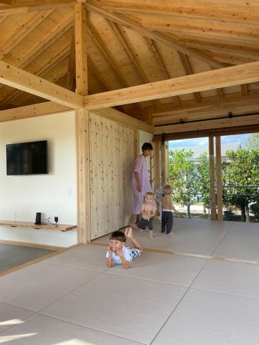two children laying on the floor of a pavilion at SHINMINKA Villa IRIOMOTE 竹盛旅館 別邸 in Iriomote