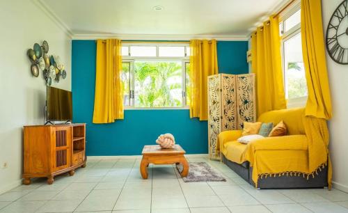 Una sala de estar con un sofá amarillo y una mesa. en Vahine Ori Lodge, en Ataiti
