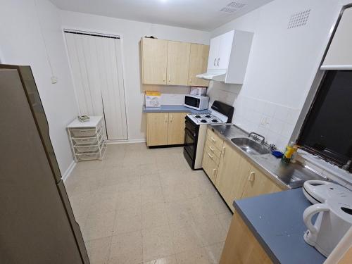 a kitchen with a sink and a stove top oven at Campbelltown Family Retreat 3-Bedroom Home in Campbelltown