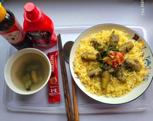 a tray with a plate of rice and a cup of tea at Hang Camping 2 in An Ninh