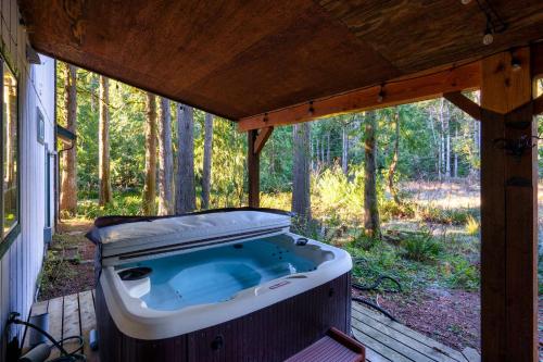 a hot tub on a porch of a house at Woodland Hideaway, Dog-Friendly, Hot Tub in Rhododendron