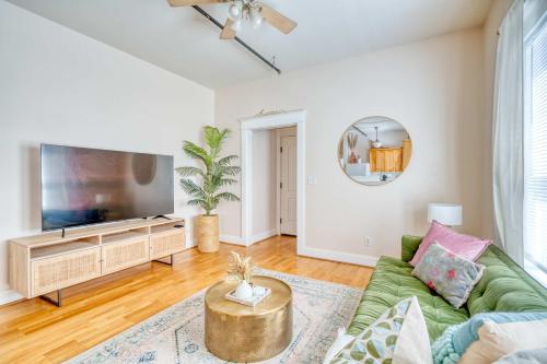 a living room with a green couch and a flat screen tv at Historic Mississippi - Live Music & Local Shops in Portland