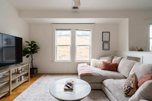 a living room with a couch and a tv at The Bohemian Spirit - Live Music, Eateries & Bars in Portland