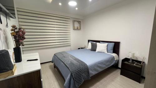 Un dormitorio con una cama y una cómoda y una ventana. en Apartamento de lujo, en Ibarra