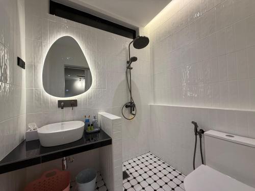 a white bathroom with a sink and a mirror at Iskandar Puteri Ensuite Room in Gelang Patah