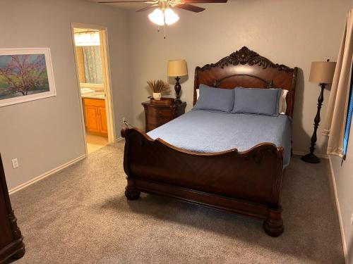 a bedroom with a large wooden bed with blue pillows at Paradise on the Prairie in Oklahoma City