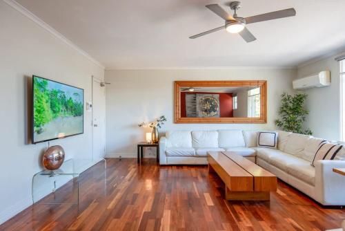 a living room with a white couch and a table at Spacious City Apartment - Walk to Casino, MCEC & MCG in Melbourne