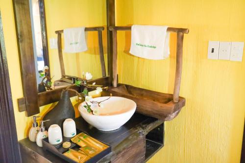 a bathroom with a bowl sink and a mirror at HaGiang Go Ecolodge in Làng Lap