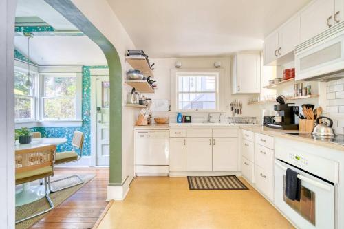 a kitchen with white cabinets and a sink at Overlook Gem - Steps from Mississippi in Portland