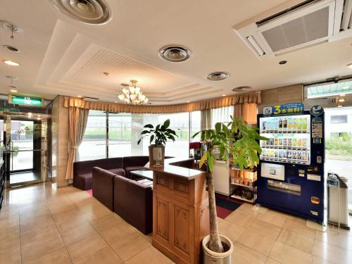 a waiting room with a couch and a potted plant at Suzuka Royal Hotel in Suzuka