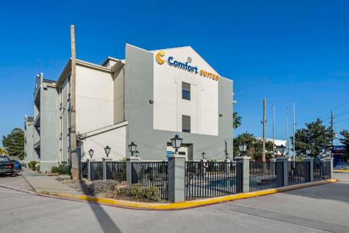 a building with a fence in front of it at Comfort Suites Houston NW - Vintage Park in Houston